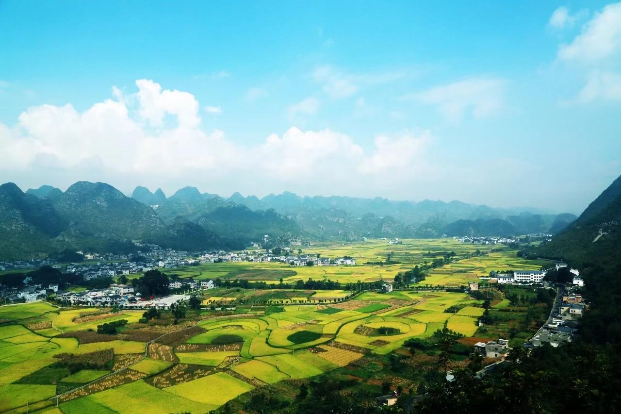 A quiet green Wanfenglin valley with a village nestled among the karst peaks near Xingyi