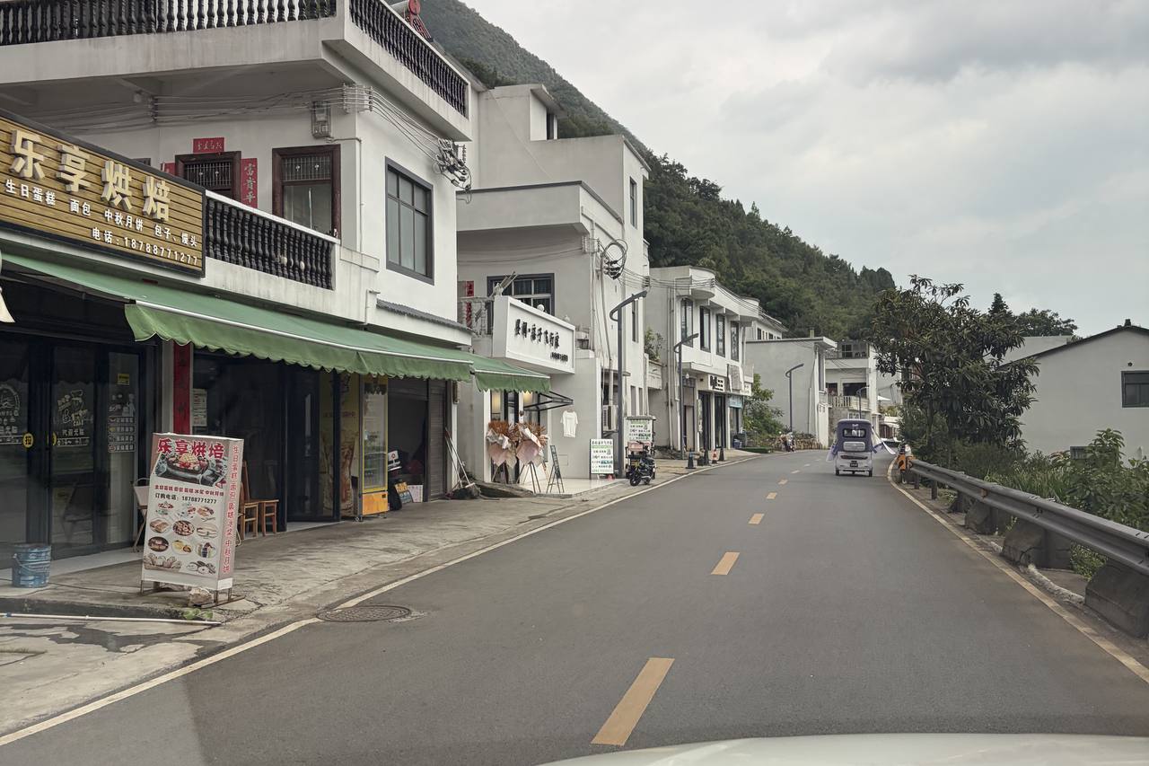 A quiet village street in the Wanfenglin valley lined with small shops and cafes